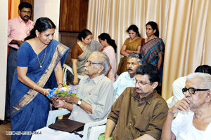 Anupama presenting bouquet to Sri. P.P.K. Poduval, who introduces the award winner and his book.