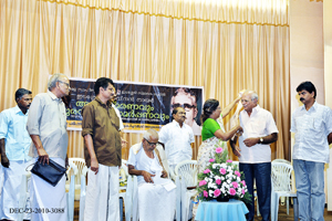 Smt. P. Vatsala, president Kerala Sahitya Akademi presenting Ponnada to Mr.K.V. John.
